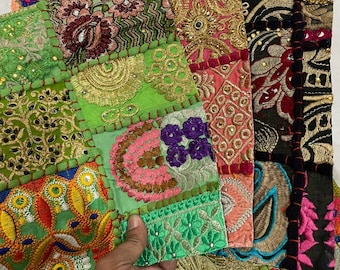 May include: A patchwork of fabric squares sewn together to create a colorful and textured throw pillow. The squares are in various shades of green, pink, red, and black, and feature intricate embroidery and beading.