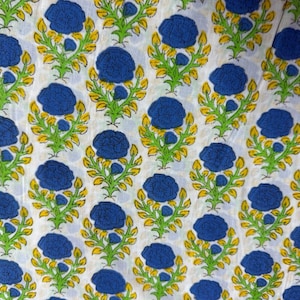 Pu&ograve; includere: Tessuto bianco con un motivo ripetuto di fiori blu, steli verdi e foglie gialle. Il design &egrave; uniformemente distanziato, creando una disposizione simmetrica. Il tessuto sembra essere di cotone, adatto a vari progetti tessili.