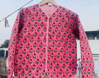 May include: A pink quilted jacket with a floral print. The jacket has a button closure and a white and pink striped lining.