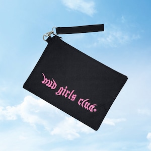 Peut inclure: Une pochette en toile noire avec un logo "bad girls club" rose et une fermeture éclair argentée. La pochette est munie d'une bandoulière noire.