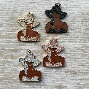 May include: Four charm pendants featuring a woman wearing a hat and swimsuit. The charms are made of metal and have a gold, silver, rose gold, and black finish. Each charm is decorated with rhinestones.