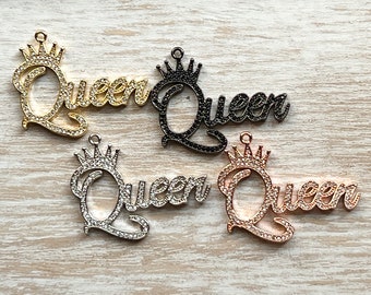 May include: Four metal charms with the word "Queen" spelled out in cursive with a crown on top. The charms are in gold, silver, rose gold, and black.