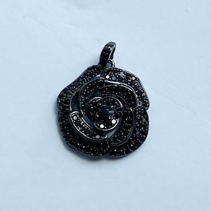 May include: Black rose pendant with black crystal accents. The pendant is made of metal and has a delicate design.