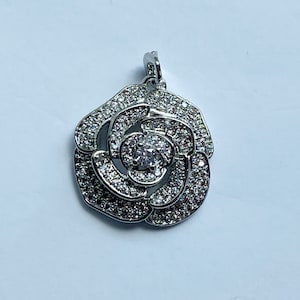 May include: Silver pendant in the shape of a rose with clear cubic zirconia stones.