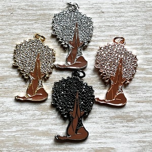 Pode incluir: Quatro pingentes que representam uma mulher com as m&atilde;os levantadas em ora&ccedil;&atilde;o. Os pingentes s&atilde;o feitos de metal e t&ecirc;m um acabamento brilhante. Os pingentes s&atilde;o de diferentes cores: prata, ouro, ouro rosa e preto.
