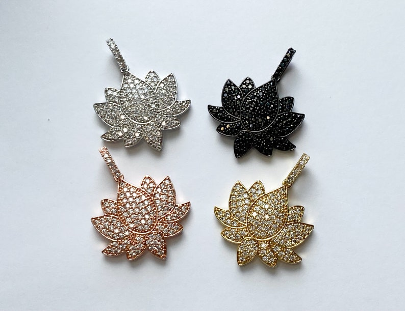 K&ouml;nnte beinhalten: Vier Lotusbl&uuml;ten-Anh&auml;nger mit Zirkonia-Steinen. Die Anh&auml;nger sind in Silber, Gold, Ros&eacute;gold und Schwarz.