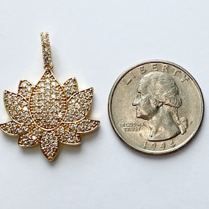 K&ouml;nnte beinhalten: Goldfarbener Lotusbl&uuml;tenanh&auml;nger mit klaren Zirkonia-Steinen. Der Anh&auml;nger ist etwa so gro&szlig; wie eine US-amerikanische 25-Cent-M&uuml;nze.