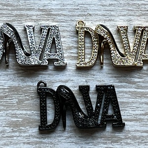 May include: Three silver, gold, and black metal charms with the word "DIVA" and a high heel shoe design. Each charm is covered in rhinestones.
