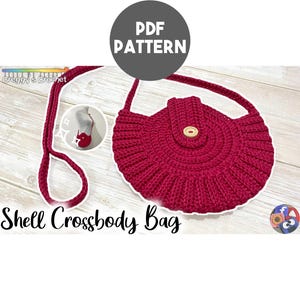 Op de afbeelding: Een donkerroze gehaakte schoudertas met een rond lichaam, een lange riem en een centrale flap die is vastgezet met een lichte knoop. De afbeelding bevat de tekst PDF PATTERN, Creggy's Crochet en Shell Crossbody Bag.