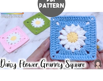 May include: A PDF pattern for a Daisy Flower Granny Square featuring three crocheted squares in blue, green, and pink. Each square has a central yellow and white daisy motif. The text "PDF PATTERN" and "Daisy Flower Granny Square" is visible.