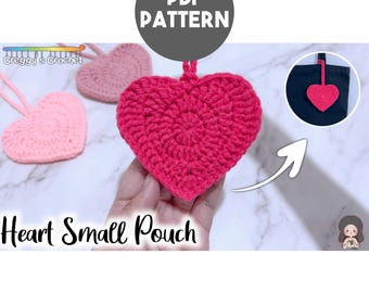 Peut inclure: Une petite pochette en crochet en forme de cœur rose vif, avec d'autres pochettes en forme de cœur rose clair et vieux rose visibles. L'image inclut le texte PDF PATTERN, Creggy's Crochet et Heart Small Pouch, avec un encart montrant la pochette sur un sac.