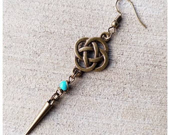 May include: A bronze earring with a Celtic knot design and a turquoise bead. The earring has a long, pointed drop.