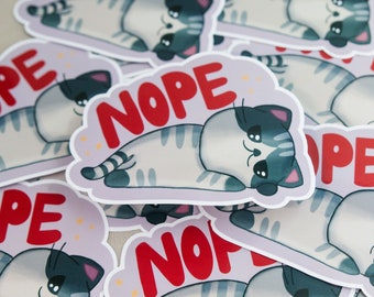 Può includere: Un set di adesivi con un gatto dei cartoni animati con la parola "NOPE" in lettere rosse. Il gatto è sdraiato sulla schiena con le zampe in aria. Gli adesivi sono stampati su carta bianca con uno sfondo viola chiaro.