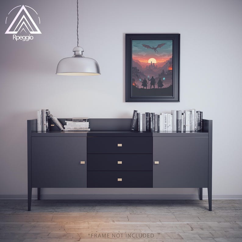 May include: A modern, dark gray sideboard with three drawers and two cabinet doors. A framed fantasy art print hangs above the sideboard, and a collection of books is displayed on top. A silver pendant light hangs from the ceiling. The text "FRAME NOT INCLUDED" is at the bottom.