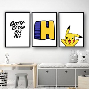 May include: Three framed prints for a child's room. The left print has black text on a white background that says "Gotta Catch Em All". The middle print has a yellow letter "H" with a blue outline on a white background. The right print has a cartoon image of Pikachu on a white background.