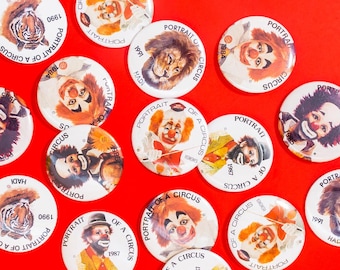 May include: A collection of colorful round pins featuring portraits of circus performers, animals, and text that reads "Portrait of a Circus".