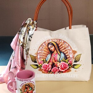 Puede incluir: Una bolsa de lona blanca con asa de cuero marr&oacute;n. La bolsa presenta una imagen colorida de la Virgen de Guadalupe con el texto "Gracias por tus bendiciones" y "Virgen de Guadalupe". La bolsa viene acompa&ntilde;ada de una bufanda rosa y una taza de cer&aacute;mica rosa con una cuchara. La taza tambi&eacute;n presenta una imagen de la Virgen de Guadalupe con el texto "Gracias por tus bendiciones" y "Virgen de Guadalupe".