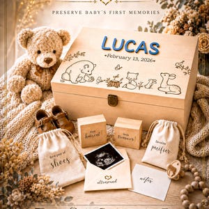 May include: A wooden keepsake box with the name LUCAS and February 13, 2026 engraved, featuring woodland animal illustrations. Includes two small wooden blocks labeled first haircut and little treasures, plus fabric bags for shoes and a pacifier.