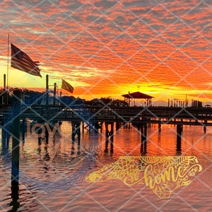 Puede incluir: Una puesta de sol pintoresca sobre un muelle de madera con una silueta de un cenador y una bandera estadounidense ondeando en la brisa. El agua refleja los tonos naranja y rosa del cielo. Las palabras "home" y "love" est&aacute;n superpuestas a la imagen.