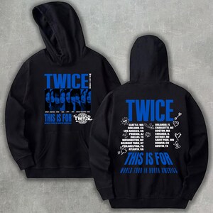 May include: Black hoodie with blue text and graphics. The front features the word "TWICE" and the phrase "THIS IS FOR TWICE" with a graphic of faces. The back displays "TWICE", a list of cities, and "THIS IS FOR WORLD TOUR IN NORTH AMERICA".