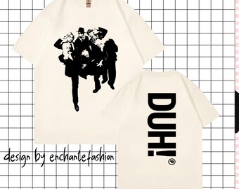 May include: Cream-colored t-shirt featuring a black and white graphic of a group of people. The back of the shirt displays the word "DUH!" in large, black capital letters. The words "design by enchantefashion" are printed at the bottom.