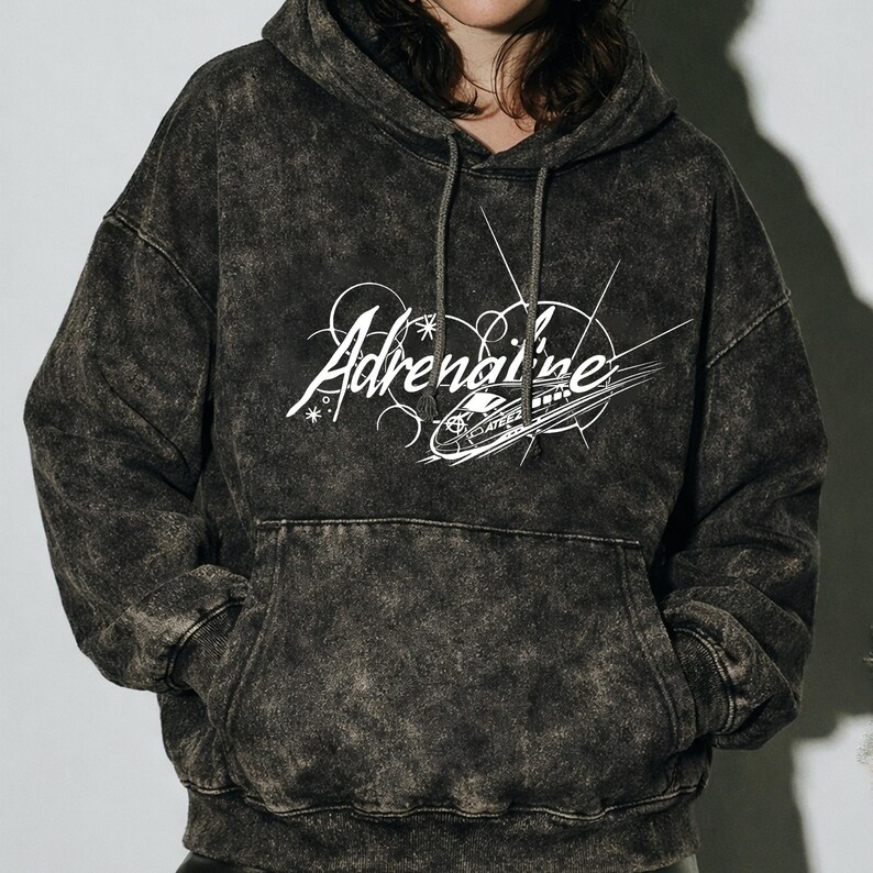 Puede incluir: Una sudadera con capucha gris oscuro con lavado &aacute;cido, con capucha con cord&oacute;n y bolsillo delantero. El gr&aacute;fico blanco en la parte delantera dice "Adrenaline" en una fuente estilizada, con un dise&ntilde;o de tren. La sudadera est&aacute; hecha de un material suave y c&oacute;modo.