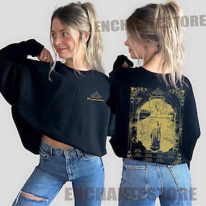 May include: Black sweatshirt with a gold graphic print of a tarot card with the text "Luck Inside the Door" and a smaller gold graphic print of a lotus flower with the text "Dreamcatcher".