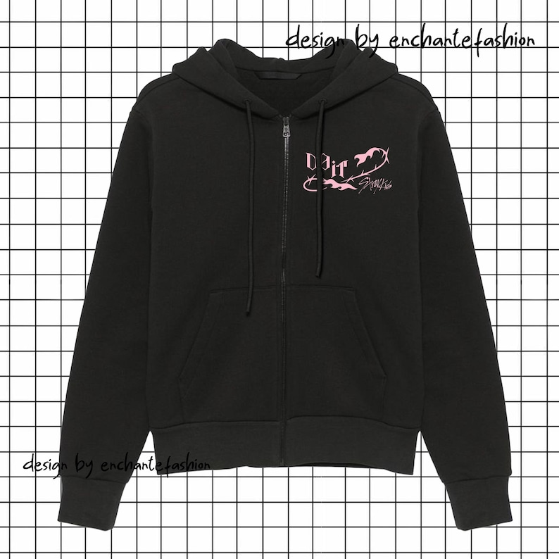 Puede incluir: Sudadera negra con cremallera, capucha con cord&oacute;n y bolsillos delanteros. La sudadera con capucha presenta texto y gr&aacute;ficos rosas en el pecho que dicen "Do it" y "Stray Kids". Las palabras "design by enchantefashion" est&aacute;n impresas en negro.