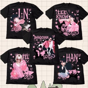 Pu&ograve; includere: T-shirt nere con grafiche rosa e bianche raffiguranti ritratti e nomi. I disegni includono testi come "IN", "LEE KNOW", "BANG CHAN", "FEL" e "HAN". Le magliette hanno un'estetica vintage e usurata con stelle, farfalle ed elementi a ragnatela.