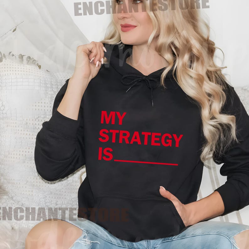 May include: Black hoodie with a red graphic that says "My Strategy Is" with a blank line underneath.