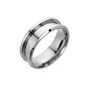 May include: A silver ring with a wide band and a grooved design. The ring is made of metal and has a polished finish.