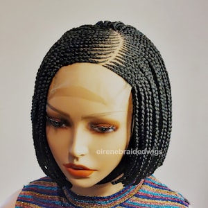 May include: A black braided wig with a bob style. The wig has a lace front and is styled with small braids.