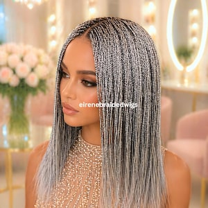 May include: A woman with long, silver and black braided hair. The braids are thin and neatly arranged, creating a sleek, straight style. The text "eirenebraidedwigs" is visible on the image. The woman is wearing a sparkly, light-colored top.