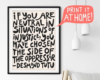 May include: Black and white typography print with a quote by Desmond Tutu: "If you are neutral in situations of injustice, you have chosen the side of the oppressor." The print is framed in a black frame and is hanging on a white wall.
