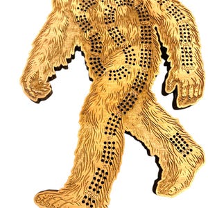 May include: A wooden cribbage board shaped like a Sasquatch, with a brown stain. The board has a path of numbered holes for playing cribbage.