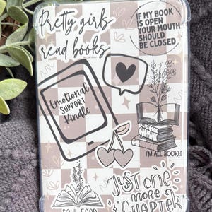 May include: Clear protective Kindle case with a light brown and white checkered pattern. The case features various graphics and text, including "Pretty girls read books," a heart, cherries, and "Emotional Support Kindle."
