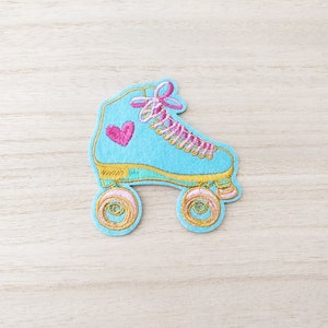 May include: A blue roller skate with pink laces and a pink heart on the side. The wheels are gold with pink accents.