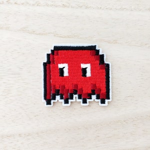 May include: Red pixelated ghost embroidered patch with black outlines and white eyes.