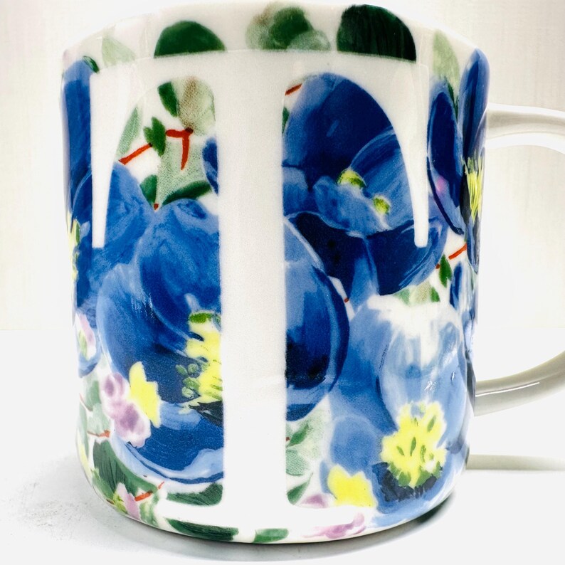 May include: A set of three ceramic mugs with a speckled, matte finish. The mugs are in shades of cream, light gray, and dark gray. Each mug has a simple, minimalist design and a rounded handle.