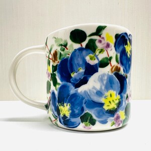 May include: A white ceramic mug with a black handle and the text "But First, Coffee" in a black, handwritten-style font. The mug is on a white surface.