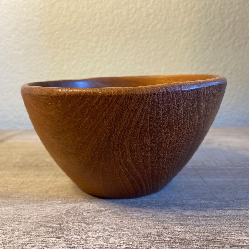 May include: A brown wooden bowl with a smooth, rounded shape and a natural wood grain pattern.