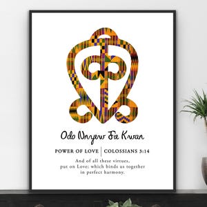 May include: A framed art print displaying a vibrant Adinkra symbol, resembling a heart, filled with patterned fabric. The text "Odo Unyew Fie Kwan" and "Power of Love" are below the symbol, along with a Bible verse.