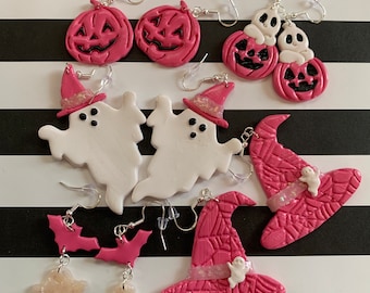 May include: A set of Halloween-themed earrings featuring pink and white polymer clay pumpkins, ghosts, bats, and witch hats. The earrings are handmade and have silver hooks.