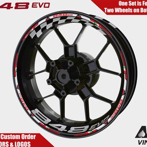 May include: Motorcycle wheel rim decals with a checkered flag design, red, white, and green accents, and the text "848 EVO".