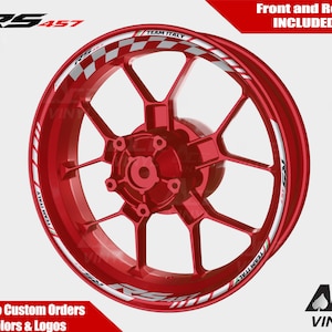 Puede incluir: Rueda de llanta de motocicleta roja con una calcomanía de rayas blancas y rojas a cuadros que dice "Team Italy". La calcomanía también incluye el texto "RS457".