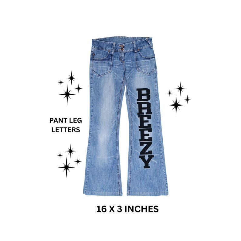 May include: Light blue denim jeans with a flared leg design. The word "BREEZY" is printed vertically in black on the right pant leg. The jeans measure 16 x 3 inches.