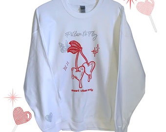 May include: White sweatshirt with a red cherry graphic and the text "Pillar to Fly" and "Sweet vibes only".