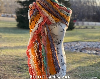 May include: A colorful crochet shawl with a picot edge, draped over a white dress form. The shawl is made with a variety of colors, including orange, yellow, green, and purple. The text "PICOT FAN WRAP" and "@sunflower_cottage_crochet" is visible at the bottom of the image.