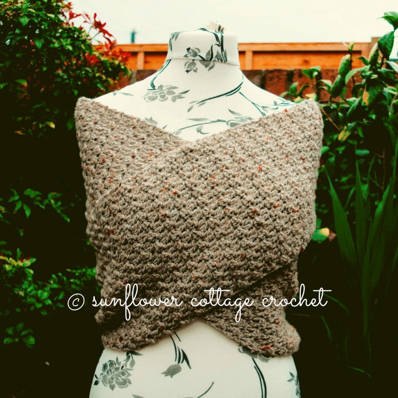 May include: A brown and orange crochet shawl with a criss-cross design. The shawl is displayed on a mannequin with a floral pattern. &copy; sunflower cottage crochet