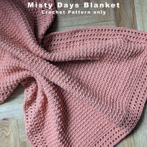 May include: A crocheted blanket in a soft, muted peach color. The blanket features a textured stitch pattern and a decorative openwork border. The text "Misty Days Blanket Crochet Pattern only" is visible in the upper left corner.